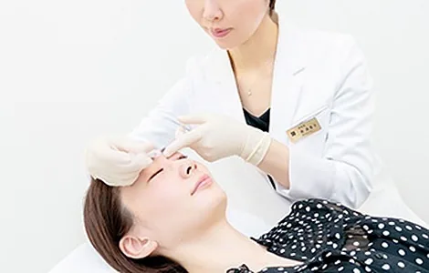 患者さんの顔に注入治療を行う副院長 奥美香子