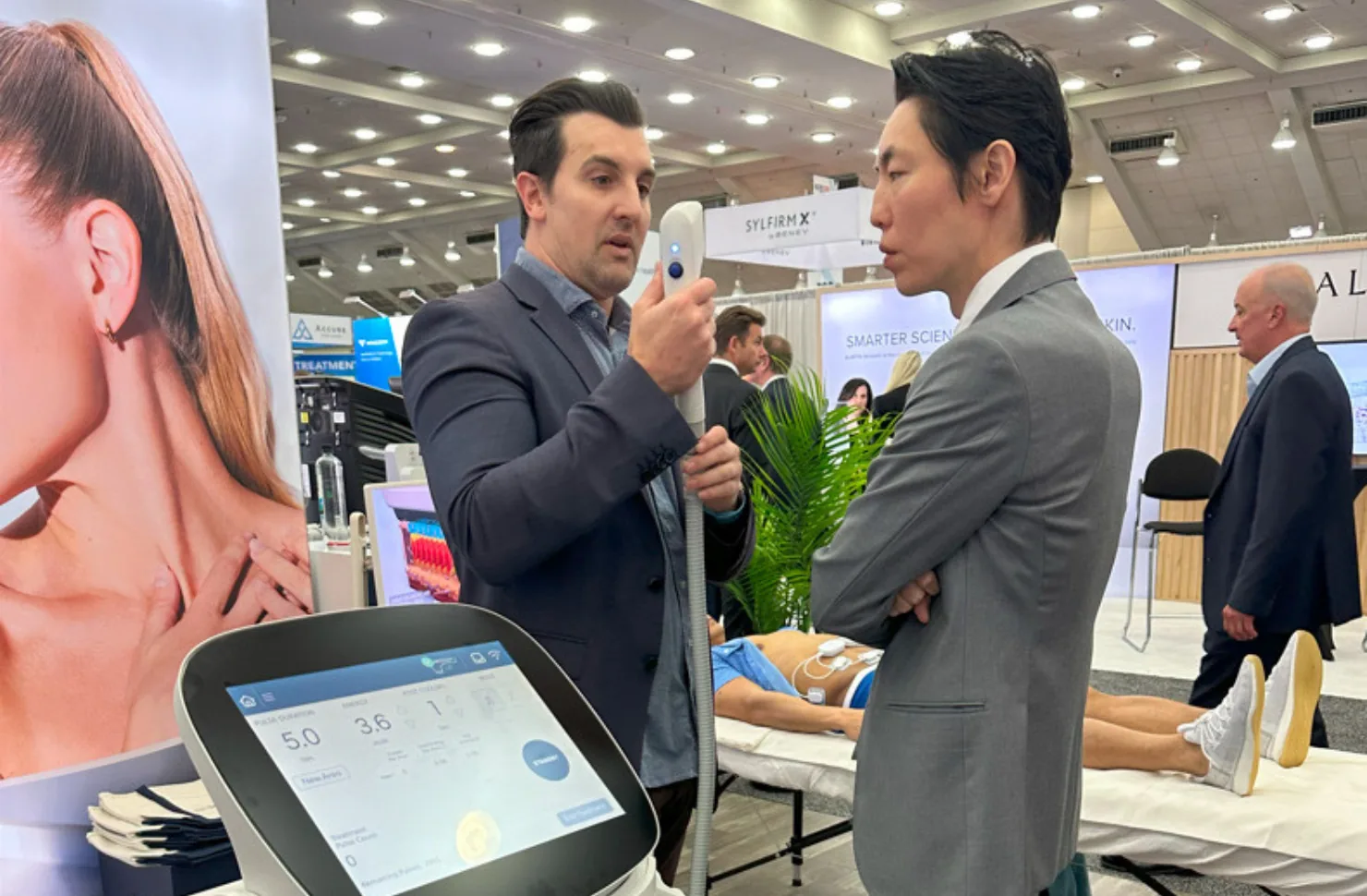 ASLMS 2024の会場で、ソフウェーブの開発責任者と意見を交わす院長