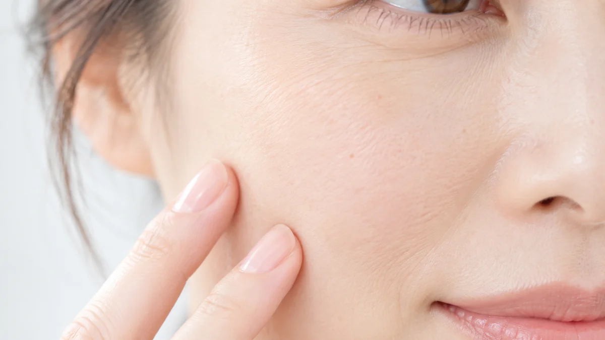 指先を添えた頬の、肌のきめ（イメージ）