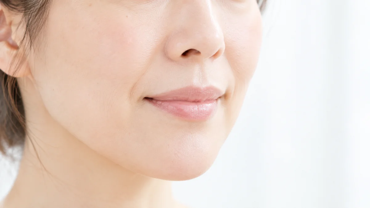 ほうれい線・口元・輪郭のイメージ写真。斜めから見た女性の、口元からあご