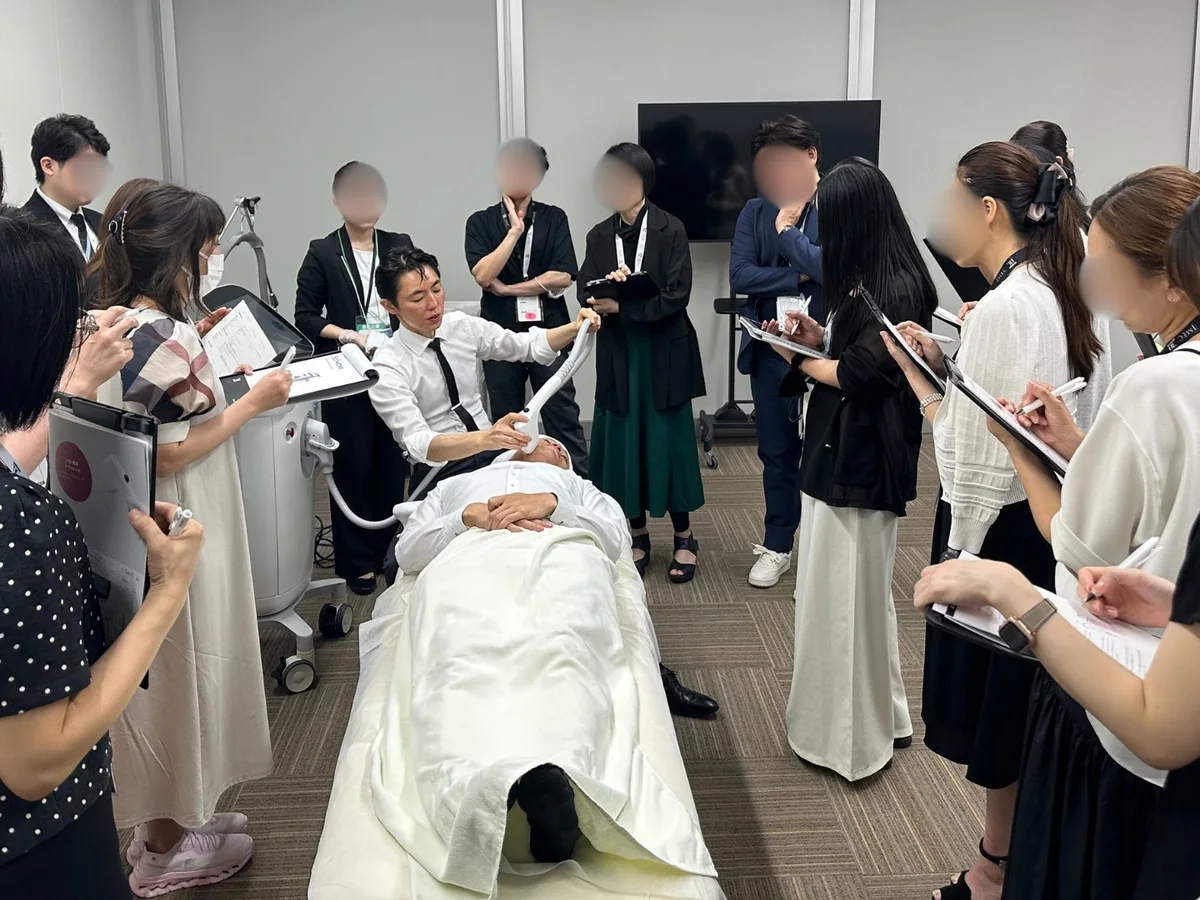 日本美容皮膚科学会（2025年）の医師向け実技トレーニングで、機器の当て方を示す院長 奥謙太郎