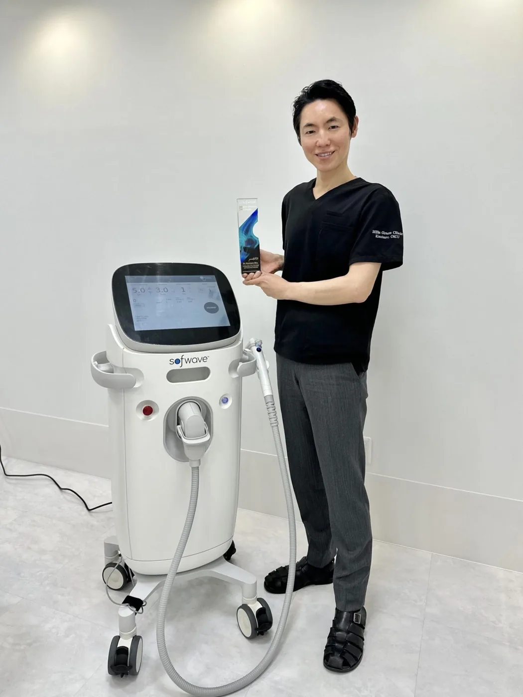 ソフウェーブの本体とともに立つ院長 奥謙太郎