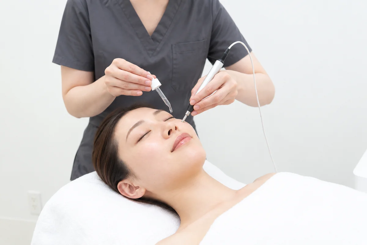 美容液を肌にのせながら、ペン型プローブで導入を行っている施術の様子